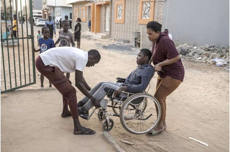 A man helps Adiaratou Ba, right, lift her son Mamadou, 13, suffering from a rare genetic disease, onto the curb in Dakar, Senegal, Saturday Jan. 11, 2025. Credit: AP Photo/Annika Hammerschlag Rare diseases often go undiagnosed or untreated in parts of Africa. A project seeks to change that